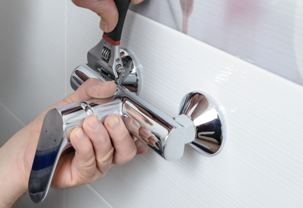 leaking tap on bathtub being repaired by plumber leaking tap on bathtub being repaired by plumber